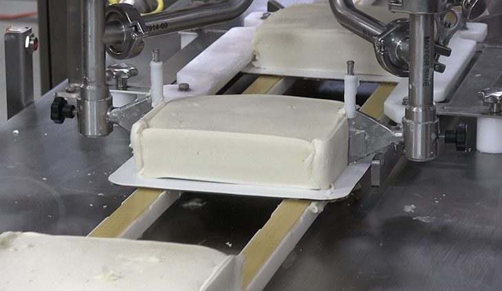 Automated sheet cake icing system for industrial bakeries